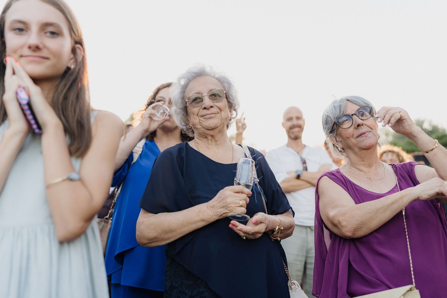 Wedding guests reacting with joy during outdoor celebration.
