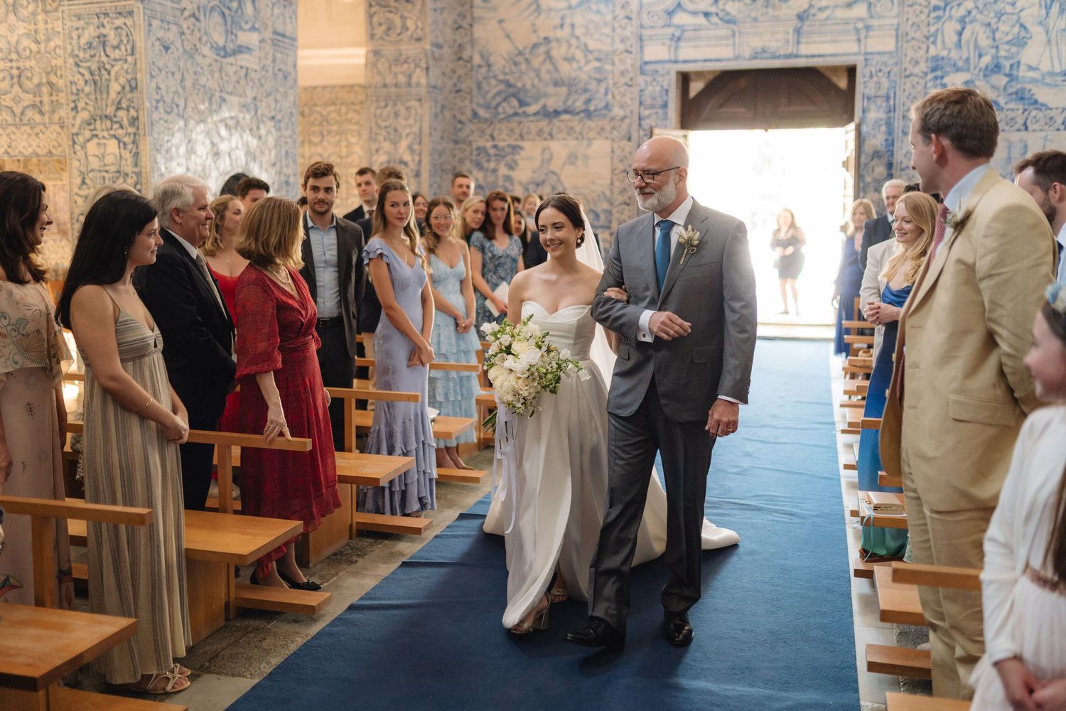 Wedding celebration inside a historic Portuguese chapel with distinctive blue tile walls and wooden benches.