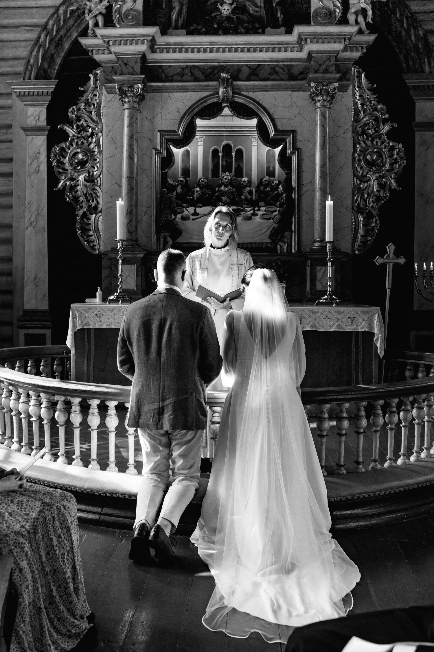 Black and white photos of a wedding ceremony inside a historic church with ornate architectural details.