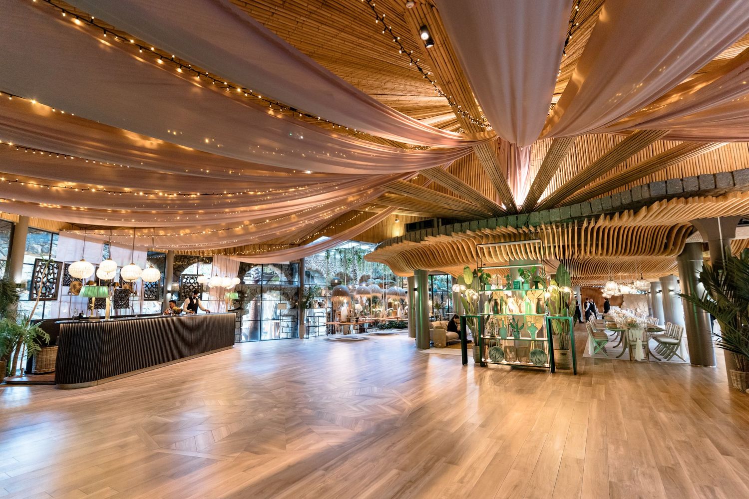 Modern event space with draped fabric ceiling and warm lighting creating an ethereal atmosphere.