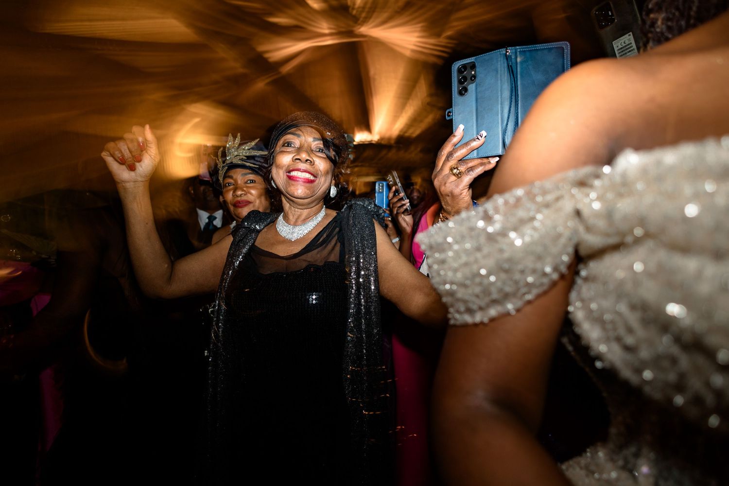 Candid moments of celebration and dancing at an evening wedding reception.