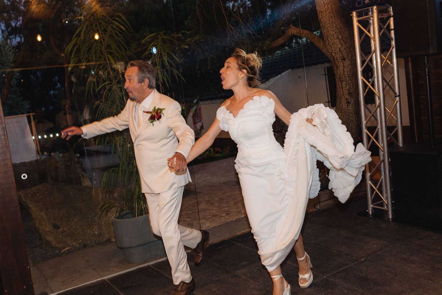 Wedding guests dancing energetically on a dimly lit dance floor at a reception celebration.