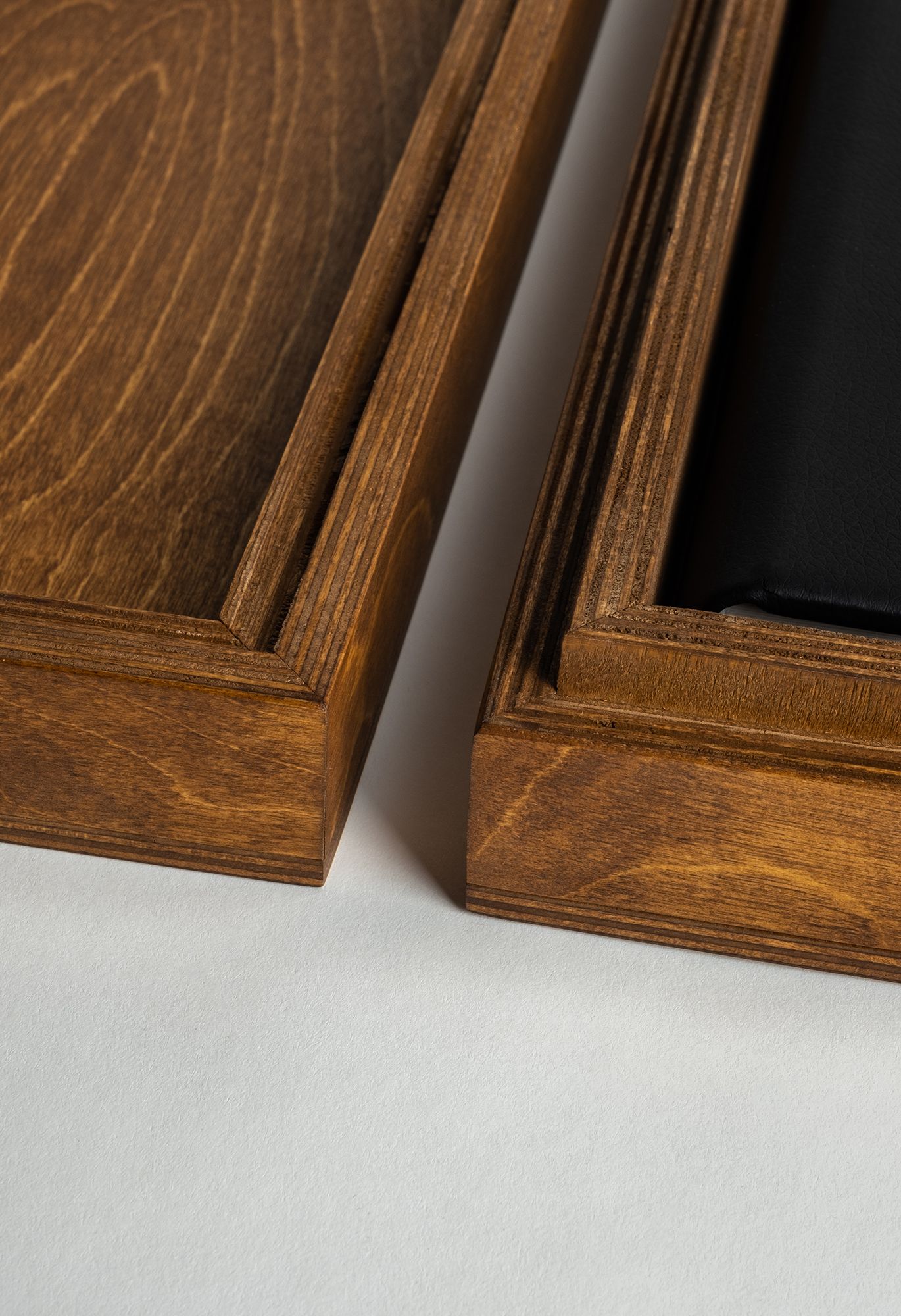 Close-up view of two brown wooden picture frames showing rich wood grain detail and corner joints.