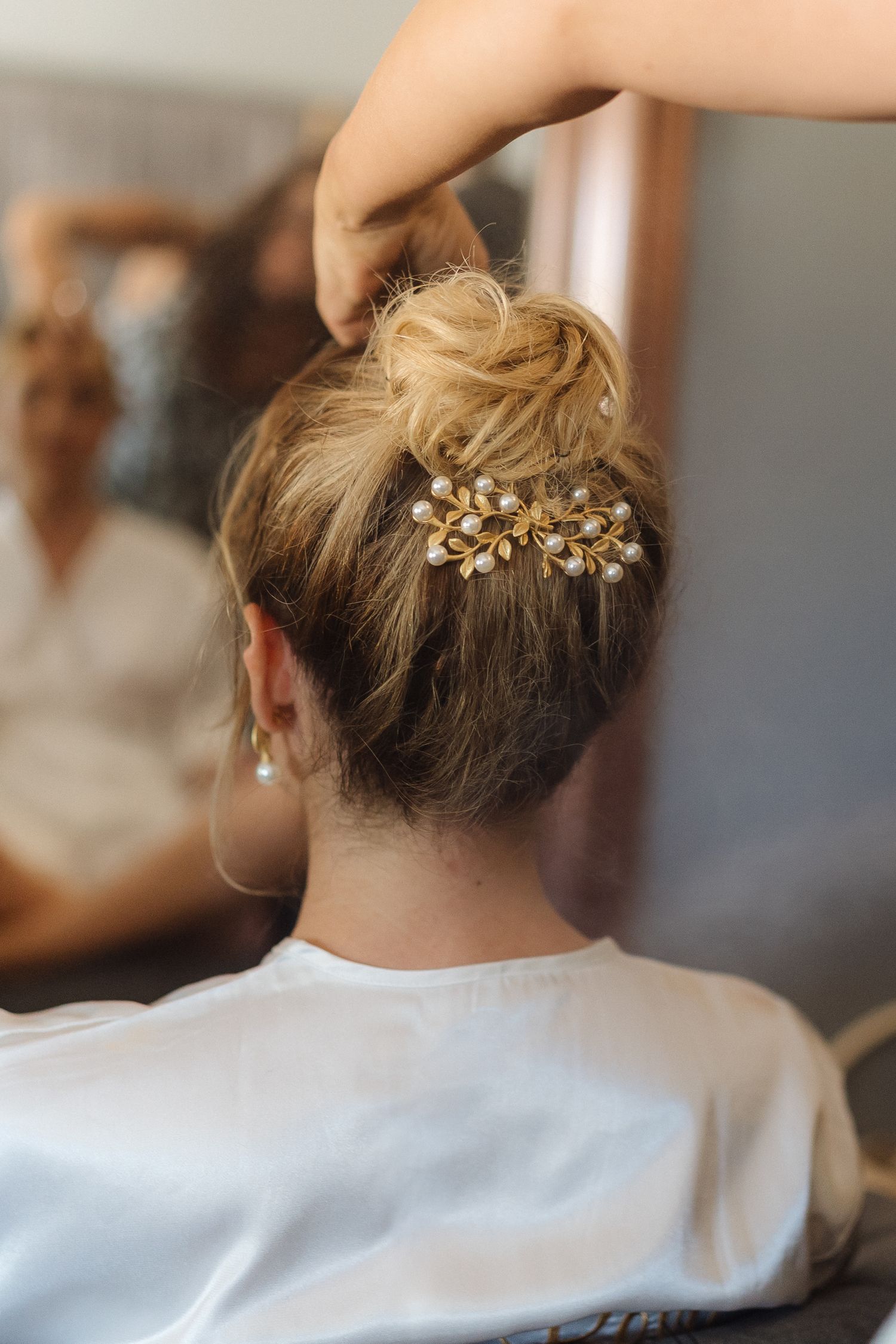 Elegant updo hairstyle adorned with decorative golden hair accessory shown from behind.