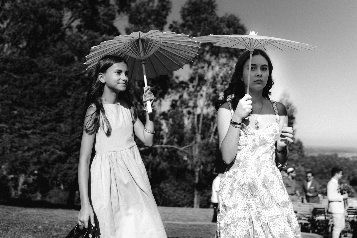 Black and white photo of wedding guests dancing and celebrating at an outdoor reception.