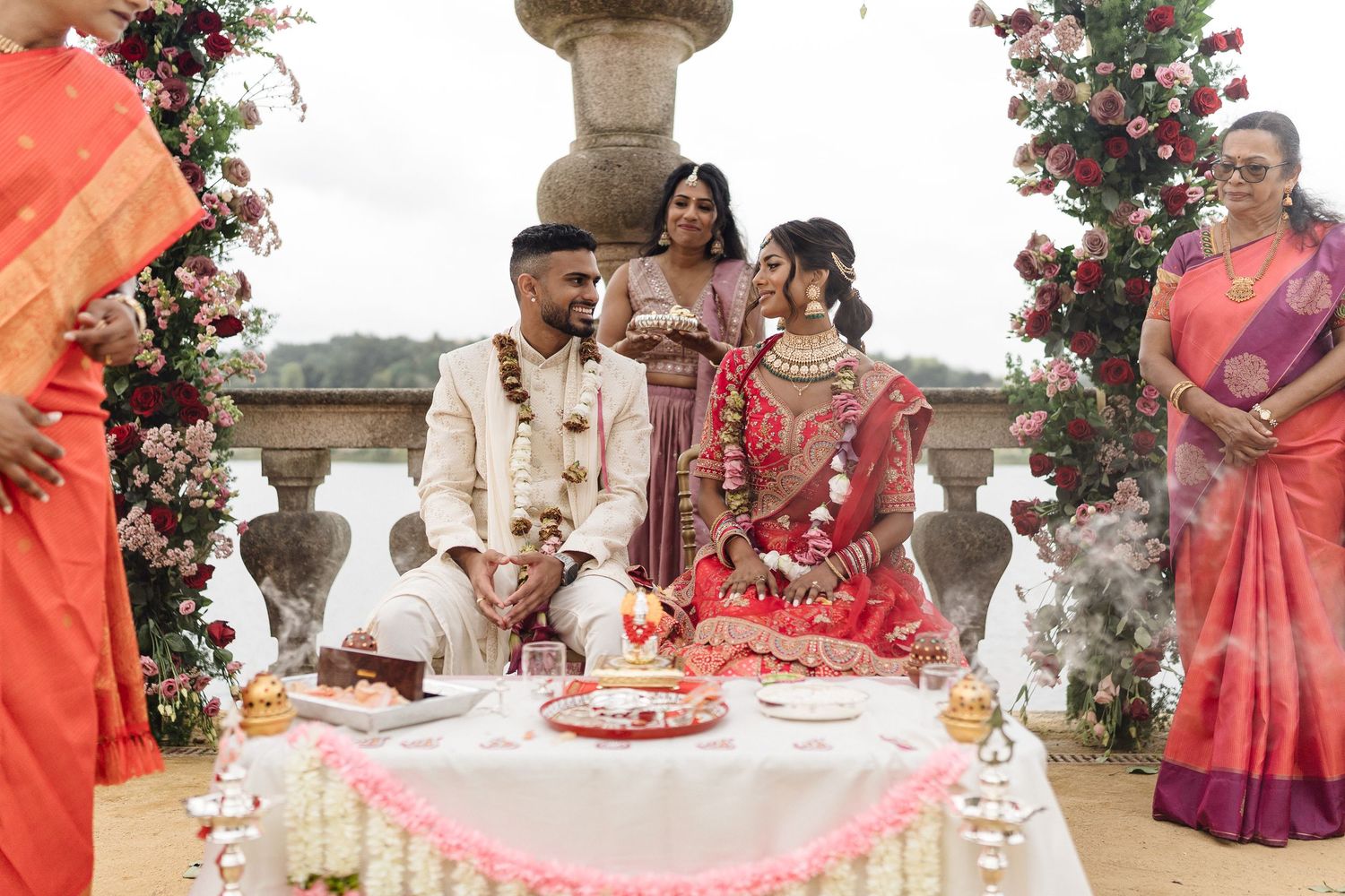 Wedding ceremony setup with floral decorations and guests gathered on a stone terrace.