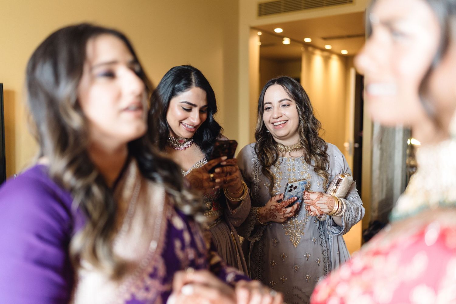 Wedding party gathering in a warmly lit room during preparations.