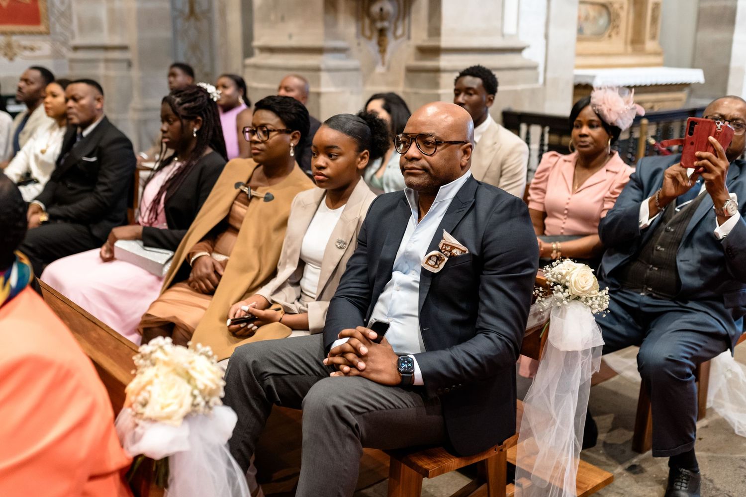 Wedding guests seated in church pews during an elegant ceremony.