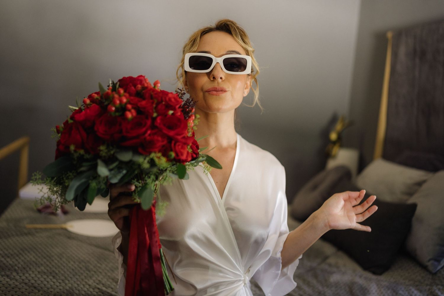 Getting ready scene with bridal robe and red floral details in morning light.