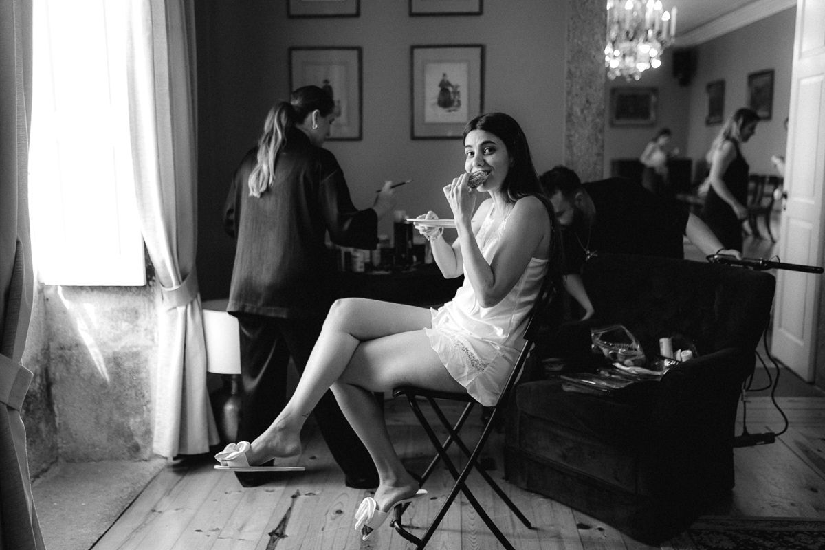 Black and white candid moments captured during wedding preparation in an interior setting.