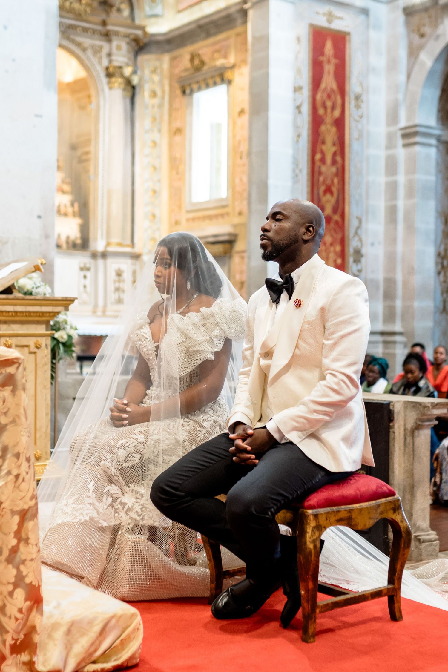A wedding ceremony taking place in an ornate cathedral with elegant decorations.