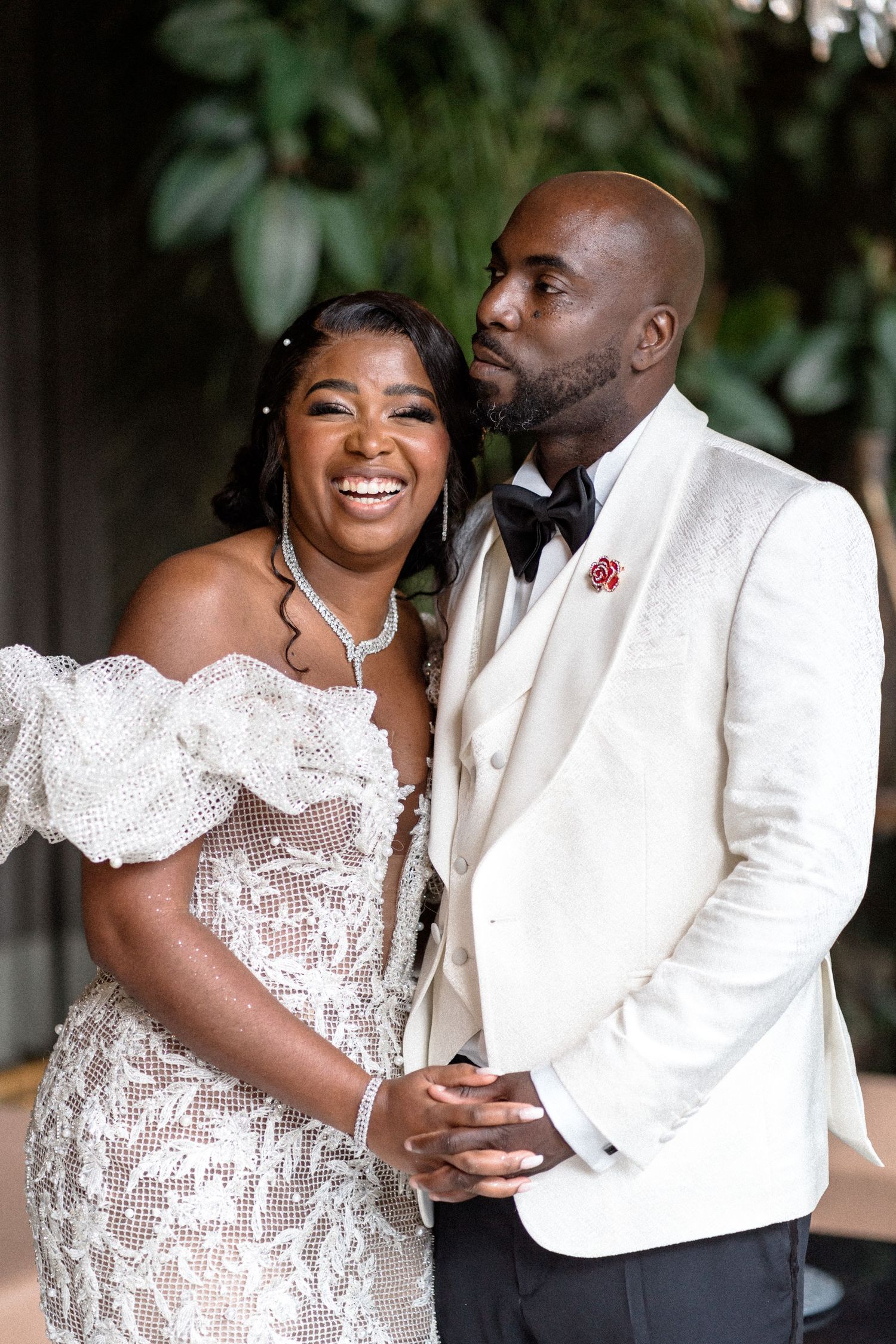 A couple shares joyful moments in elegant white wedding attire during their celebration.