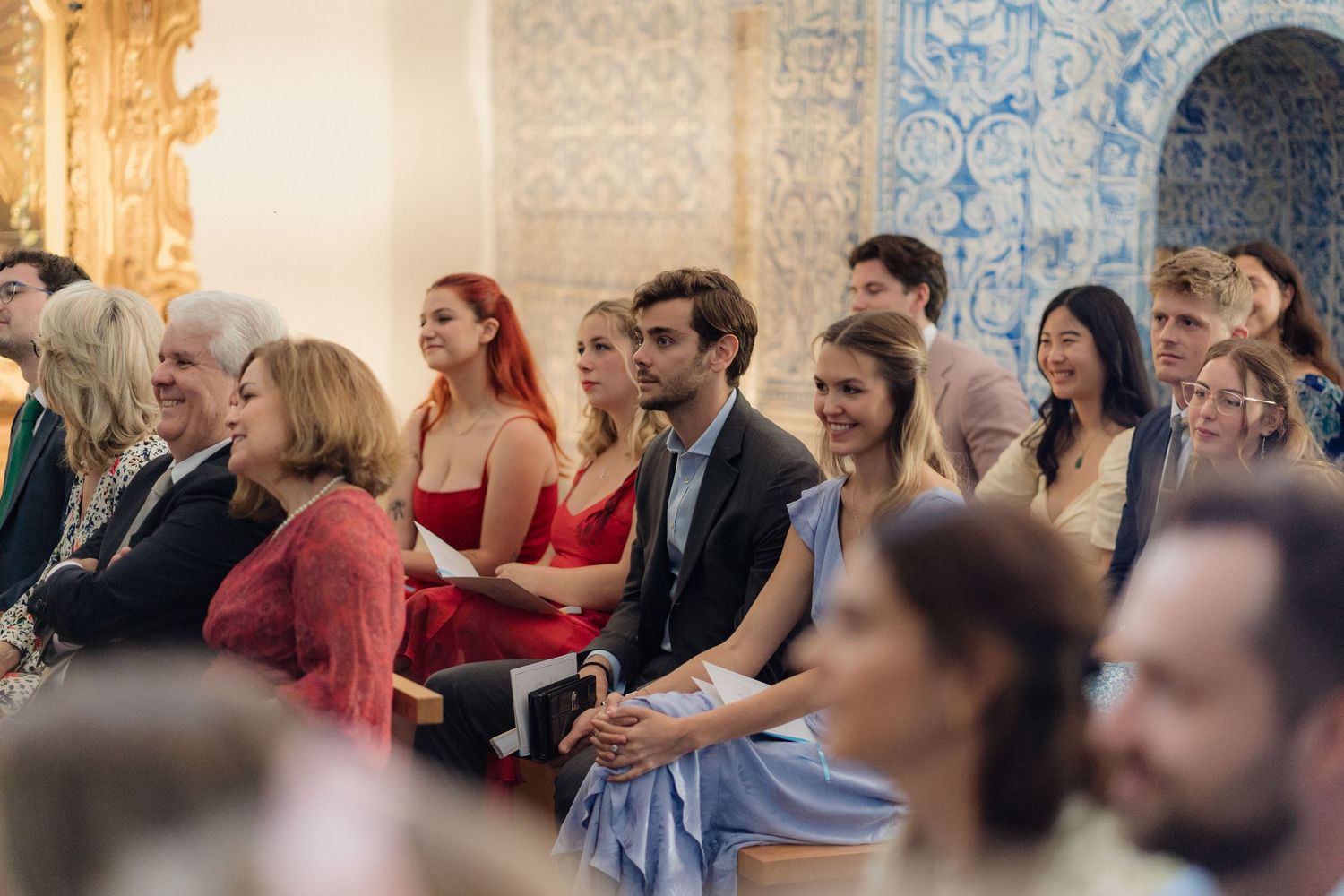 Wedding guests seated in wooden pews during an elegant ceremony.