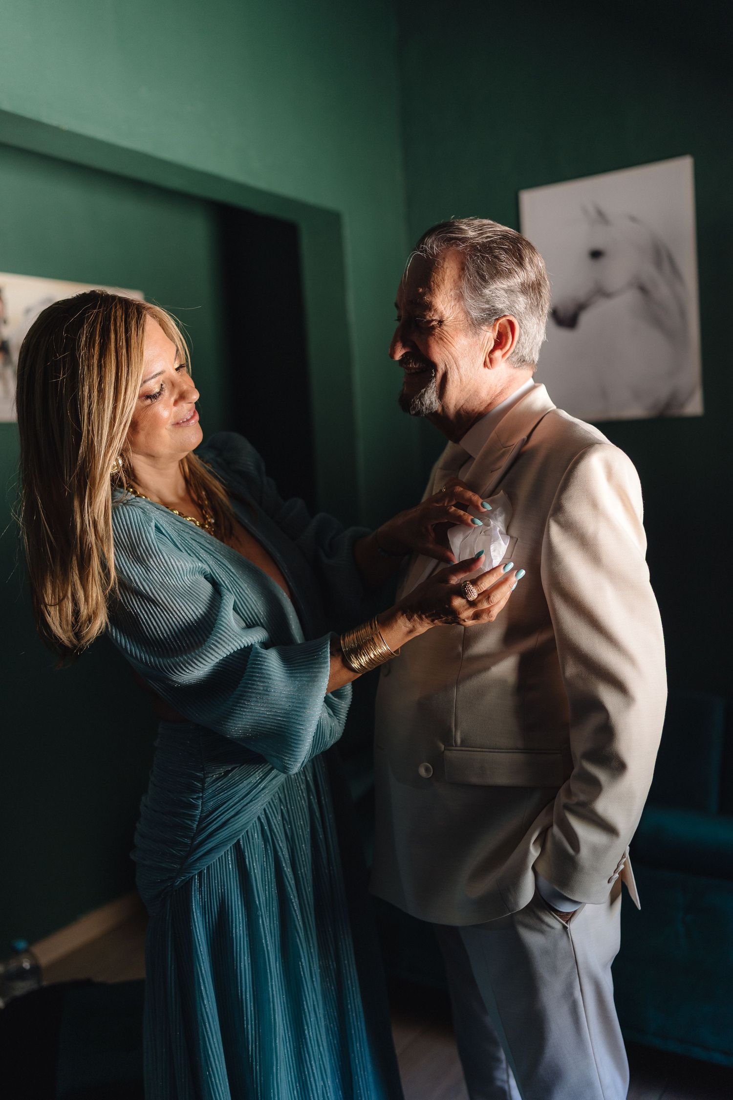 Two people dancing together in a room with green walls and dramatic lighting.