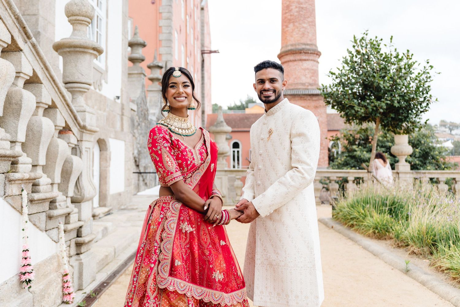 Elegant outdoor wedding photoshoot with architectural columns and stone balustrades.