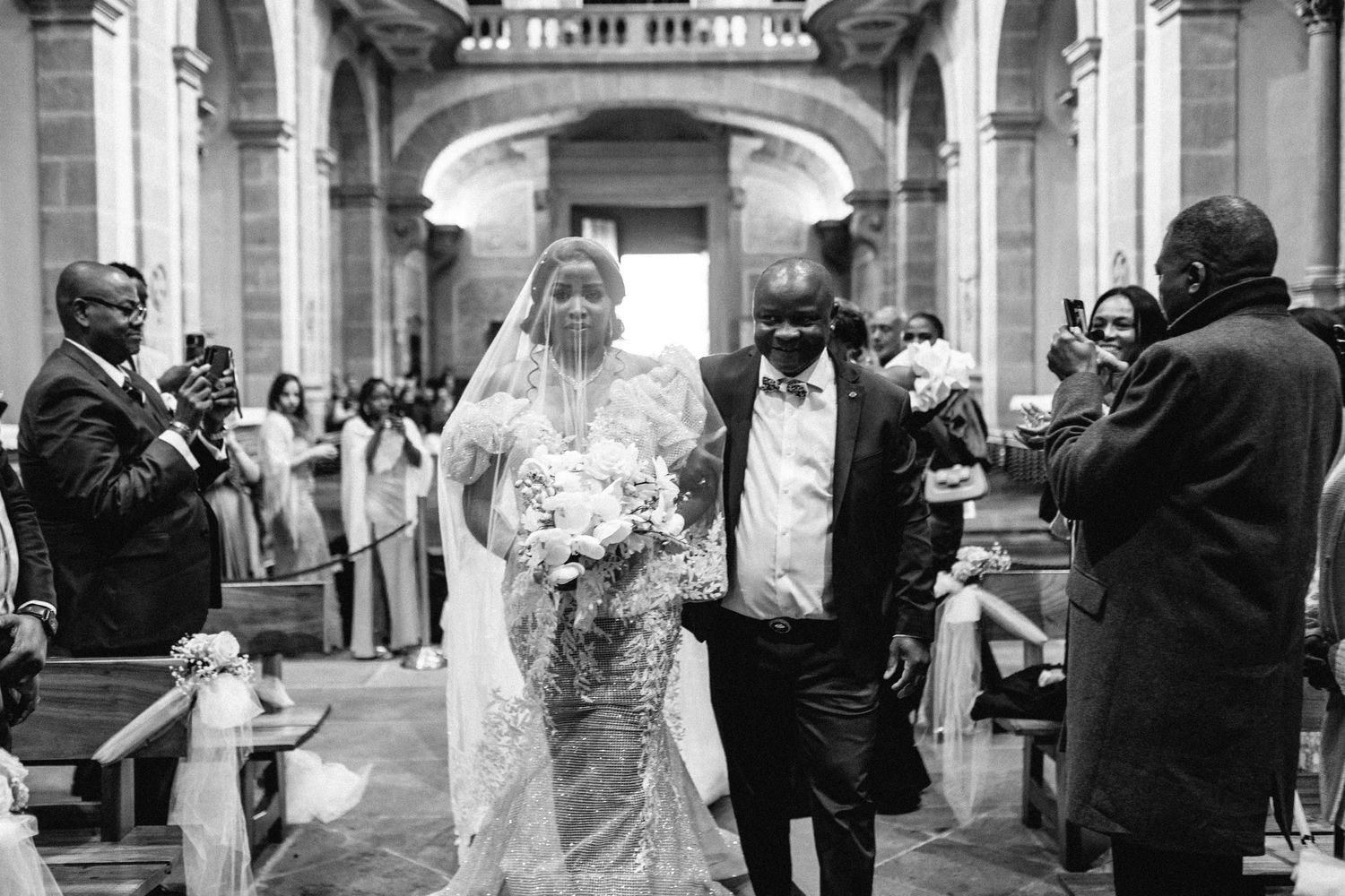 Black and white photos of a wedding celebration in an elegant church with arched architecture.