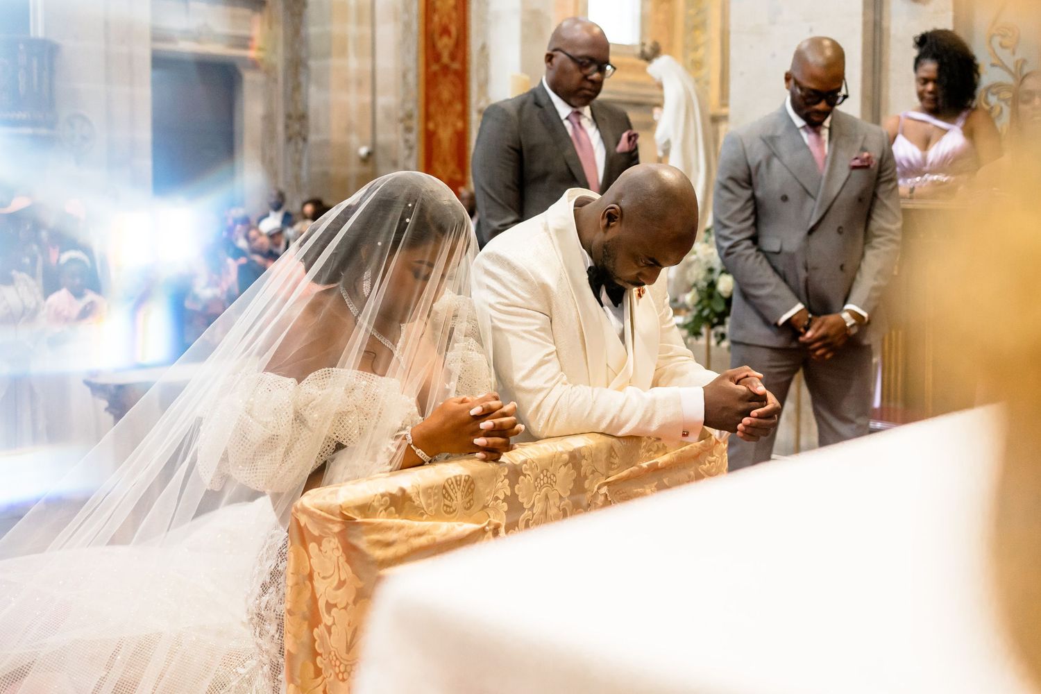 Intimate moment during wedding ceremony in historic church interior.