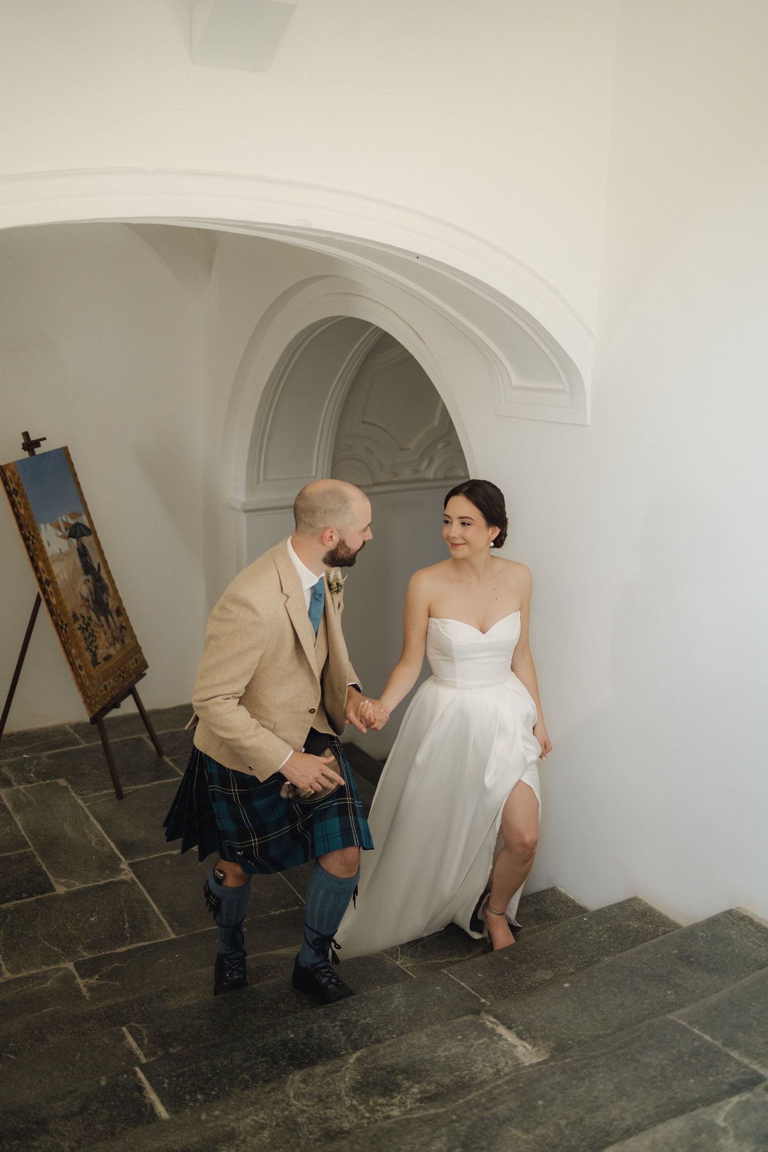 Wedding portraits captured under white arched doorways in a historic setting.