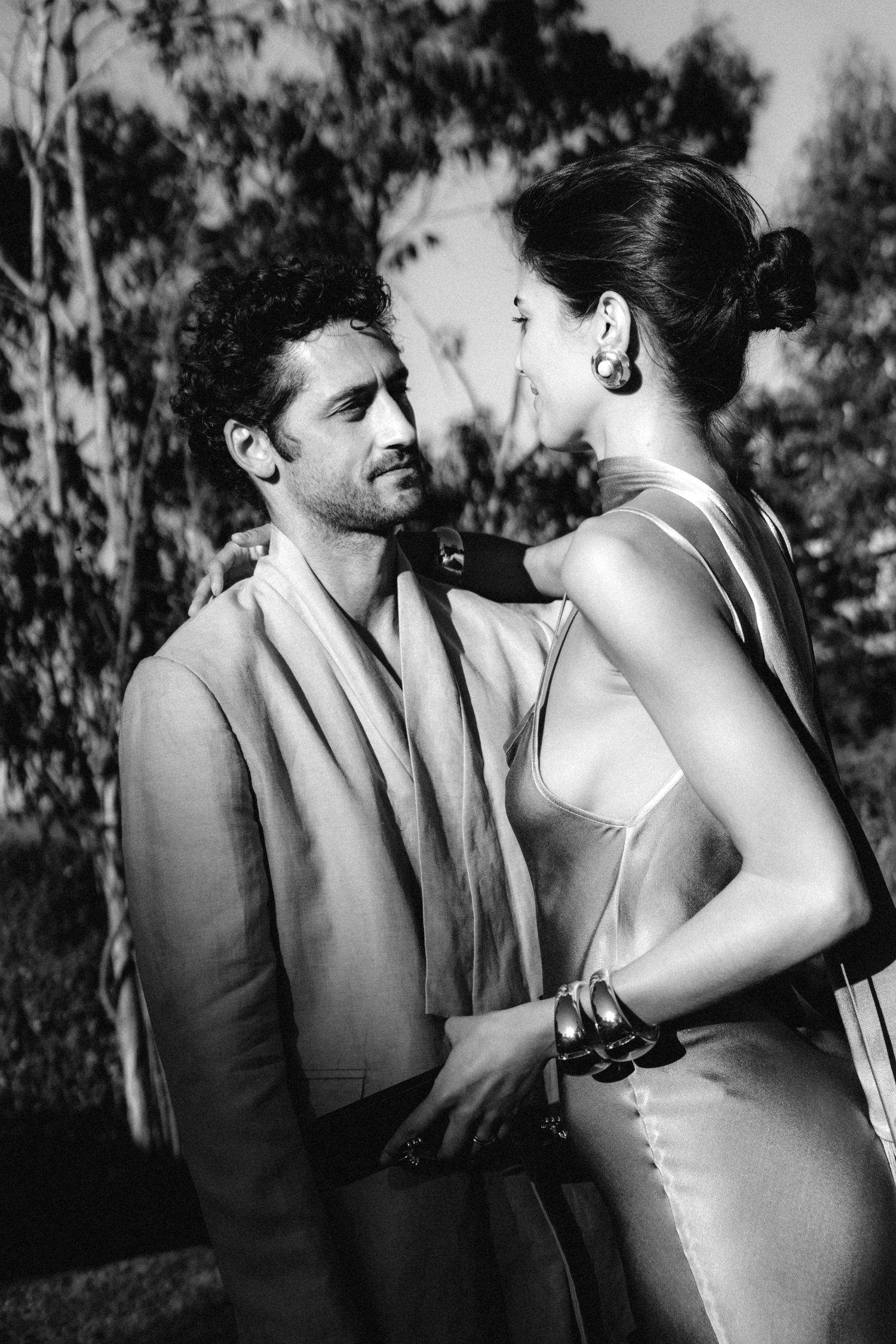 Black and white candid moment between two people at an outdoor event.