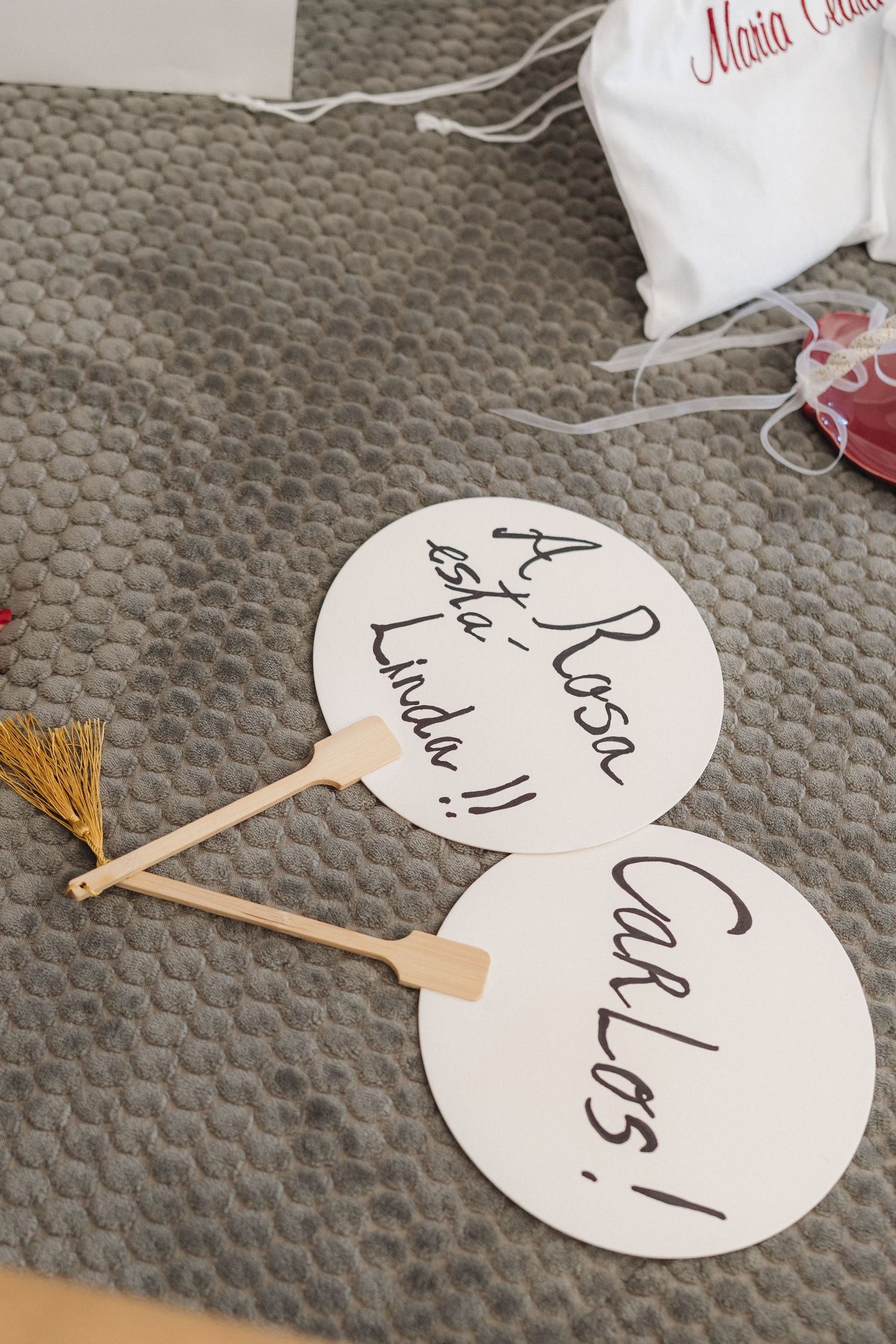 Heart-shaped wedding signs with handwritten text on a textured gray surface.