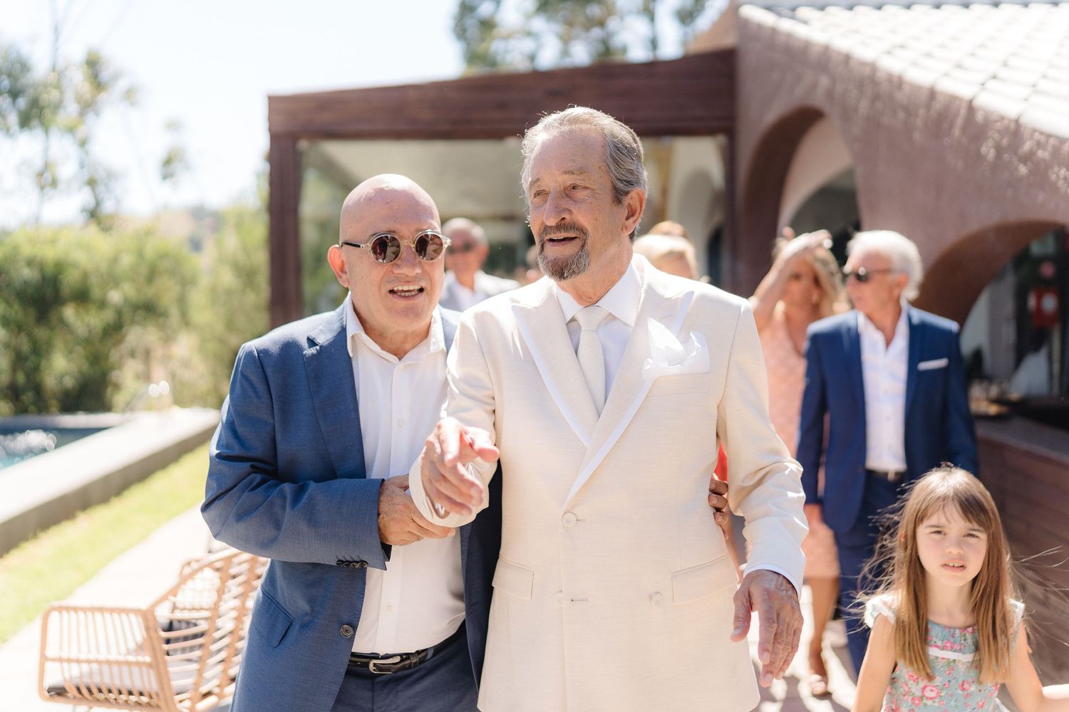 Candid moments of wedding guests interacting at an outdoor venue.