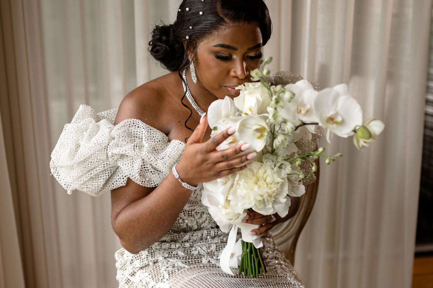 A close-up of white orchid bouquets being held during an elegant wedding ceremony.