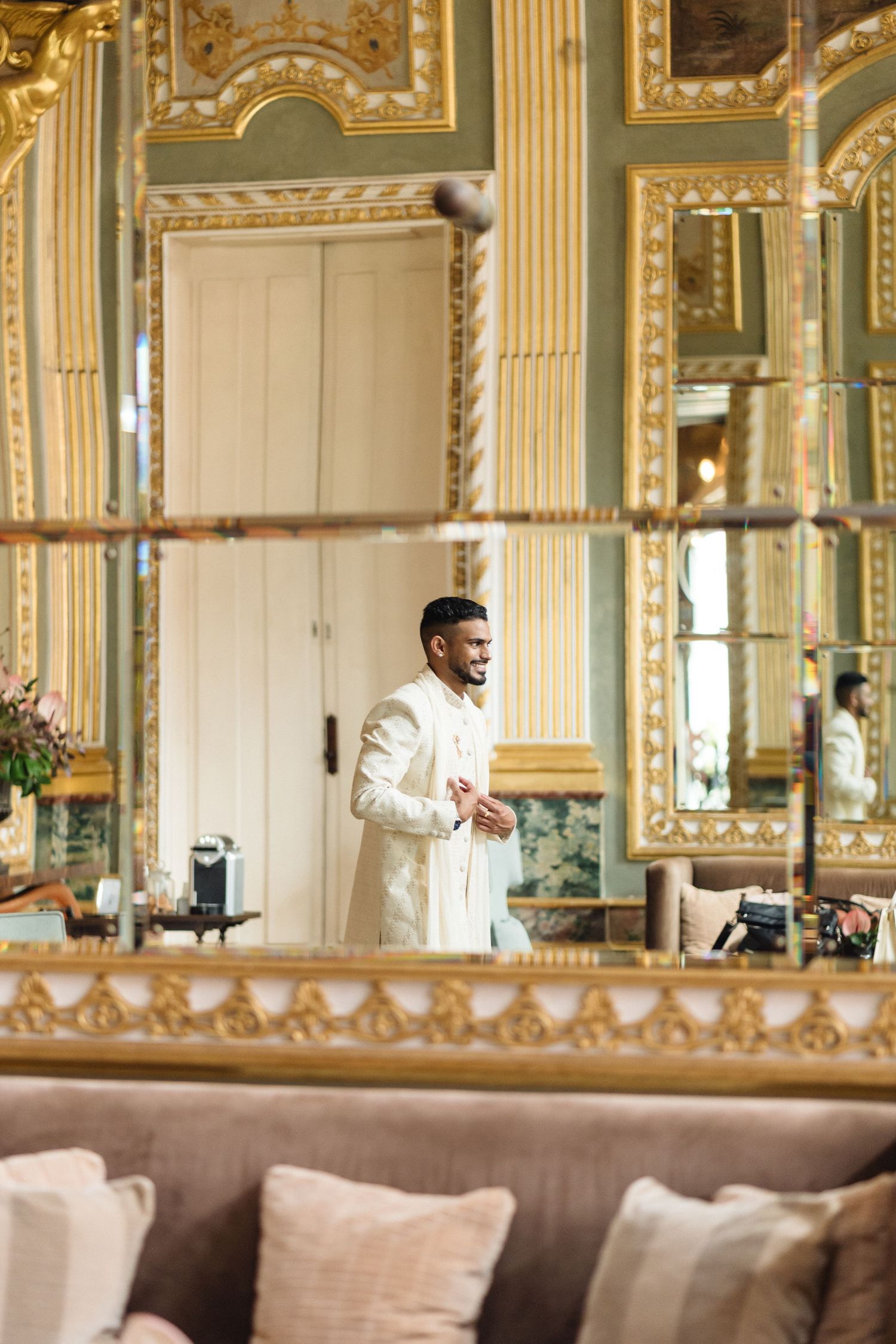 Elegant interior of a luxurious room with gold-trimmed mirrors and ornate decor.