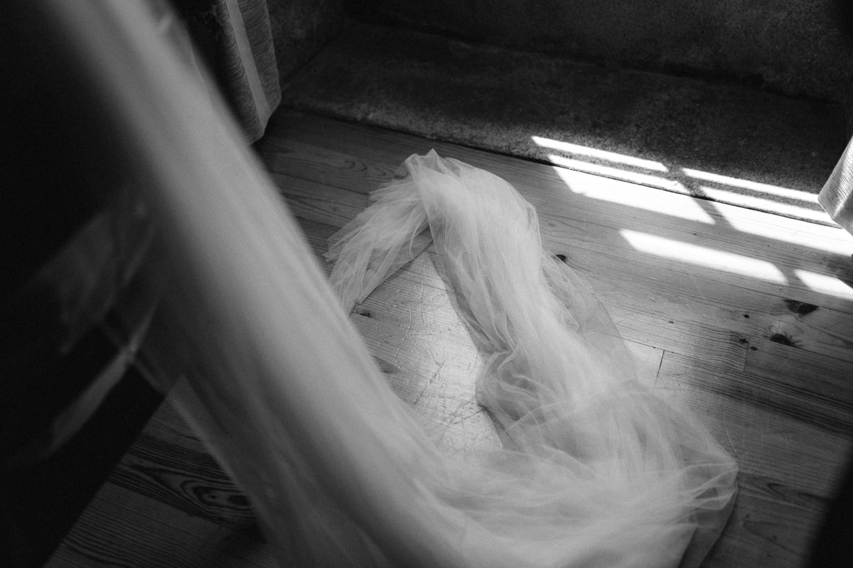 Flowing white wedding dress fabric creates ethereal movement in dramatic lighting.