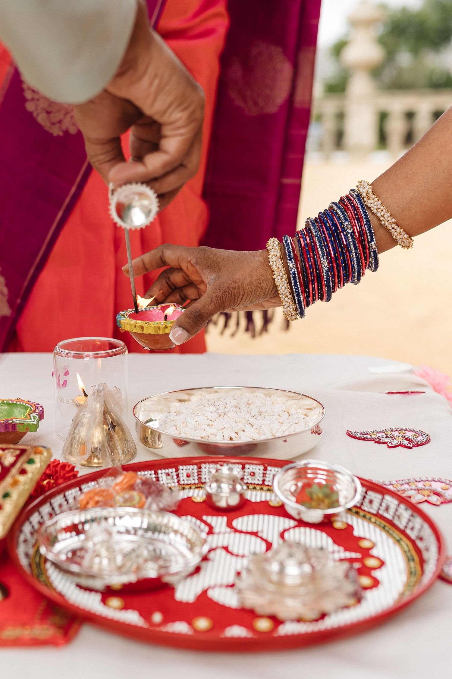 Traditional Indian wedding ceremony items arranged on decorative red and gold plates.