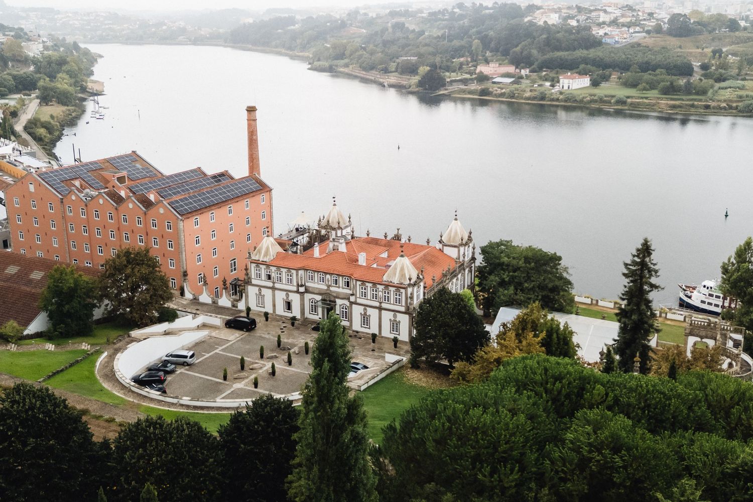 Panoramic aerial view of a riverside industrial district with historic brick buildings and waterfront development.