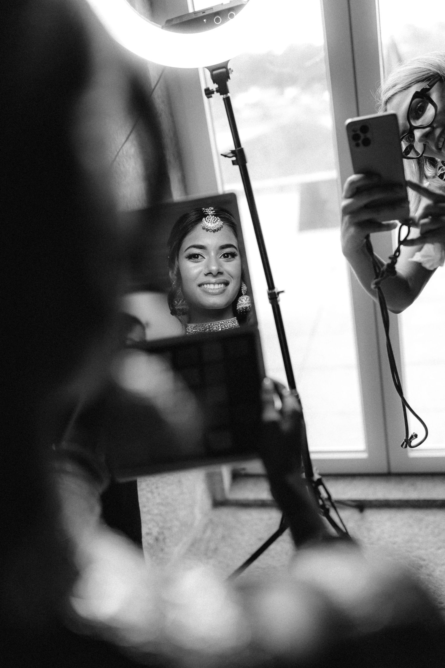 Black and white behind-the-scenes shots of wedding preparation with professional lighting equipment.
