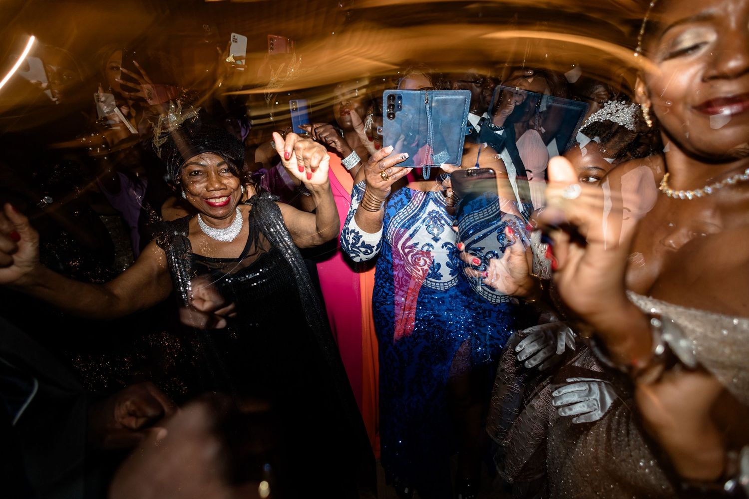 Energetic wedding reception dance party with guests celebrating on a crowded dance floor.