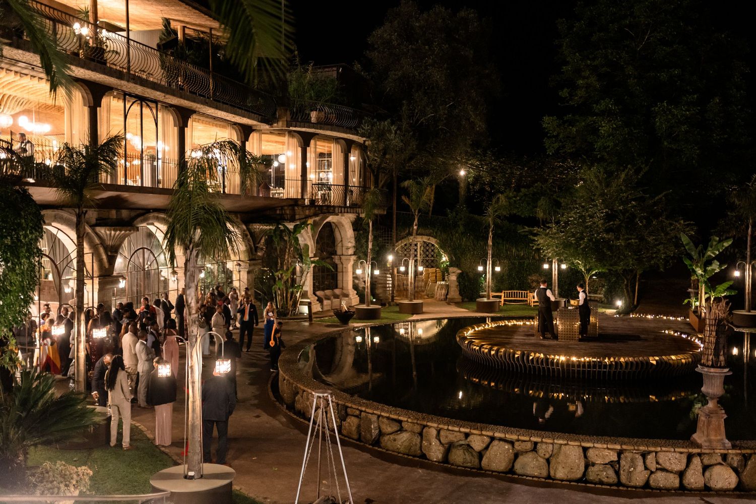 Evening outdoor reception venue with string lights and stone pathways.