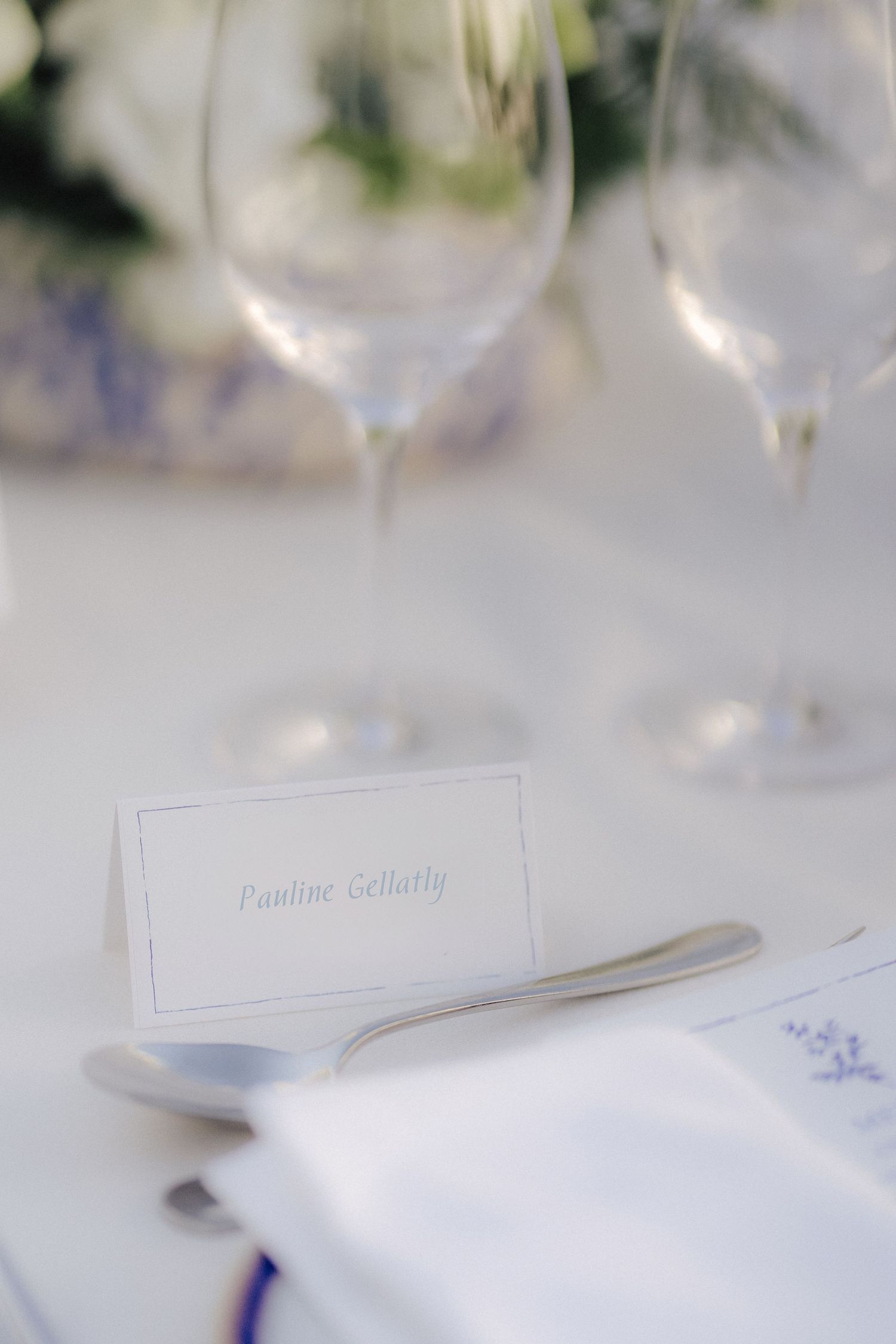 Minimalist white place cards set on elegant table settings for a formal event.