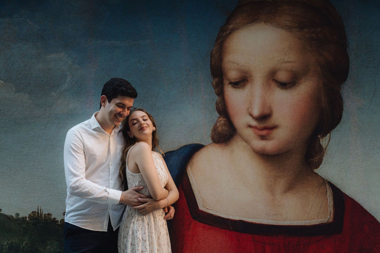 Couple embracing in front of a classic Renaissance painting of a woman in a museum gallery.