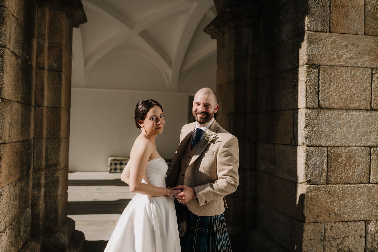 A sequence of intimate wedding photos captured under a stone colonnade.