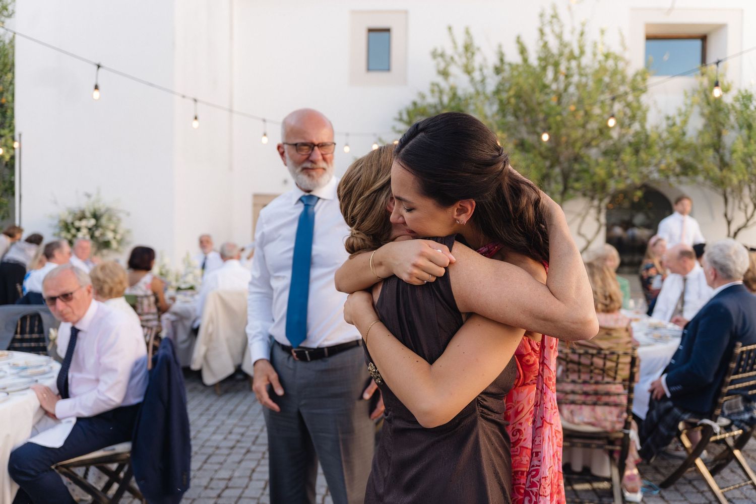 Guests dancing and celebrating at an outdoor evening wedding reception.