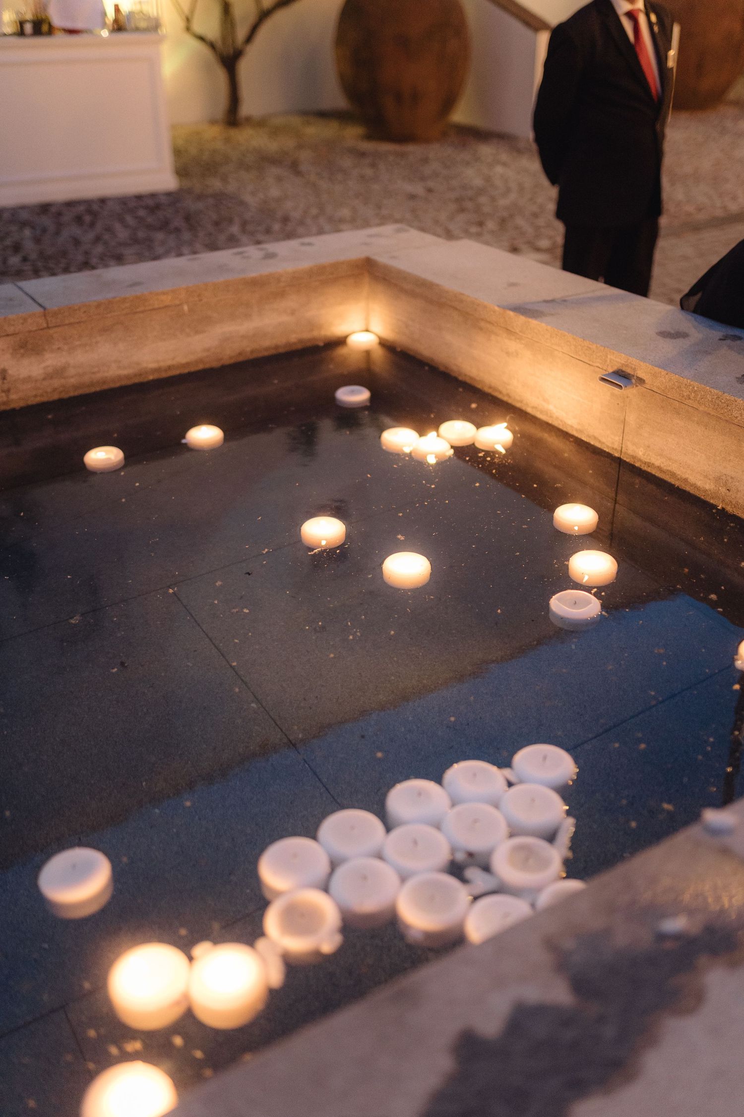 Tea light candles arranged on a dark stone surface creating romantic ambiance.