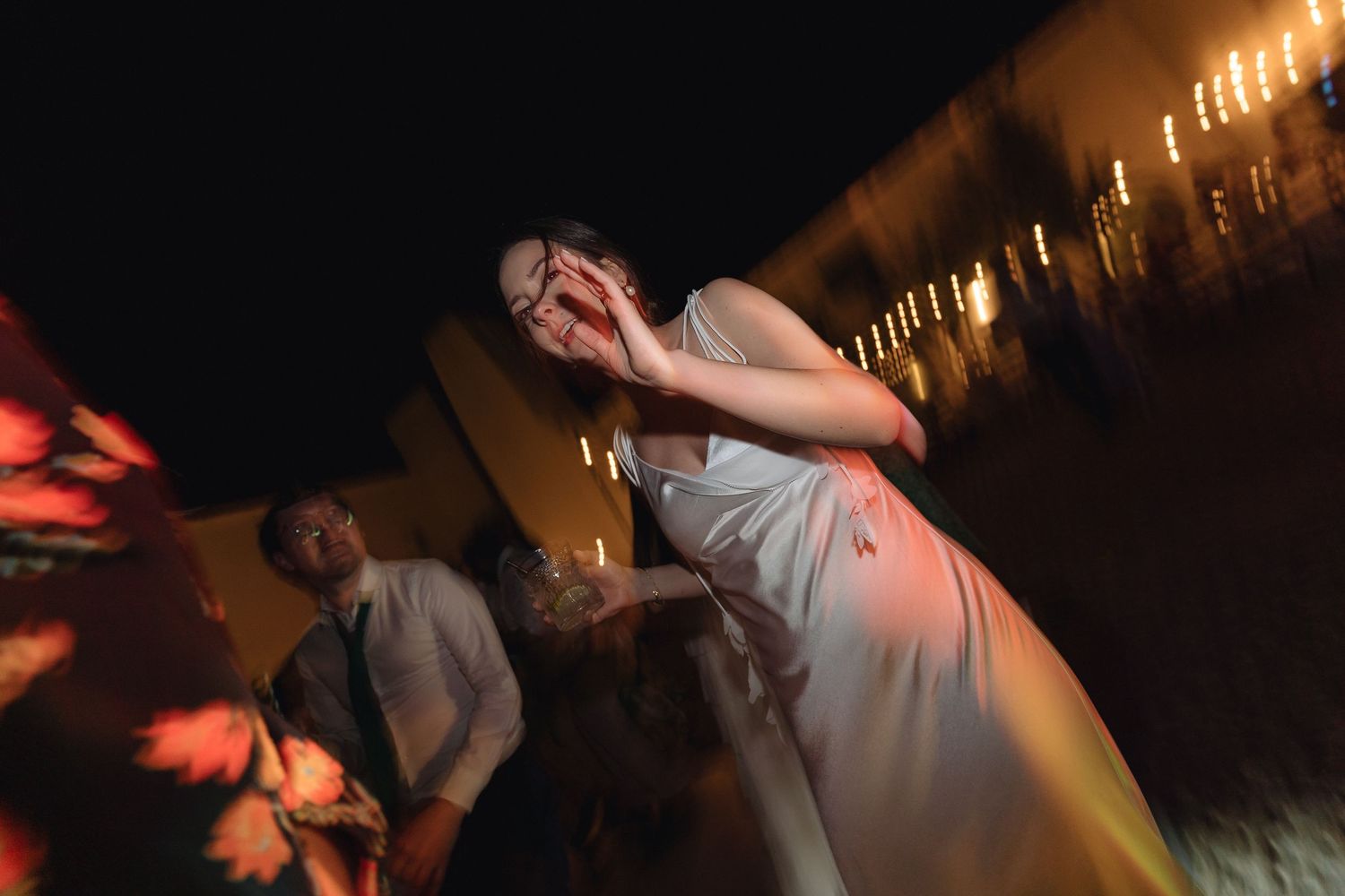 Party scene with warm string lighting and dancing silhouettes.