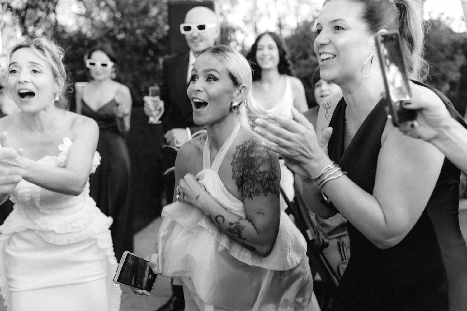 Black and white photos capturing joyful reactions during wedding celebrations.