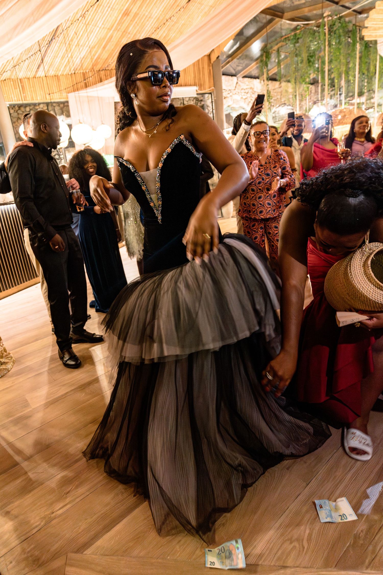 A celebration scene with dancers in formal attire under a tent-style venue.