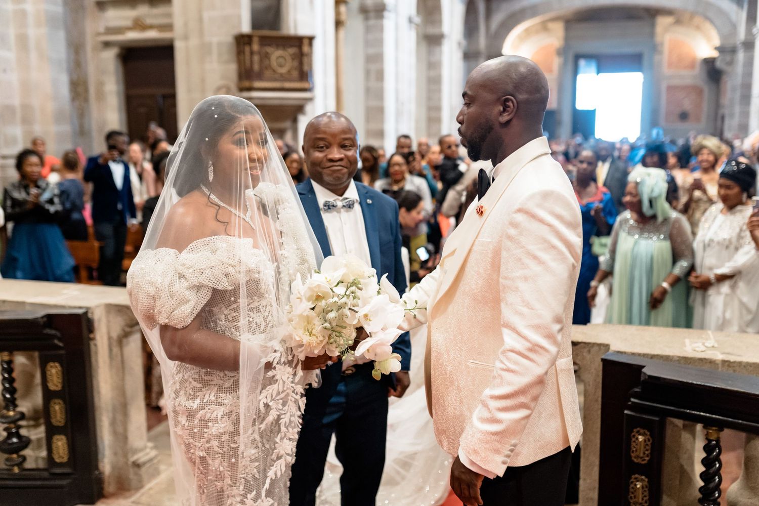 Wedding ceremony in grand church with couple exchanging vows at altar.