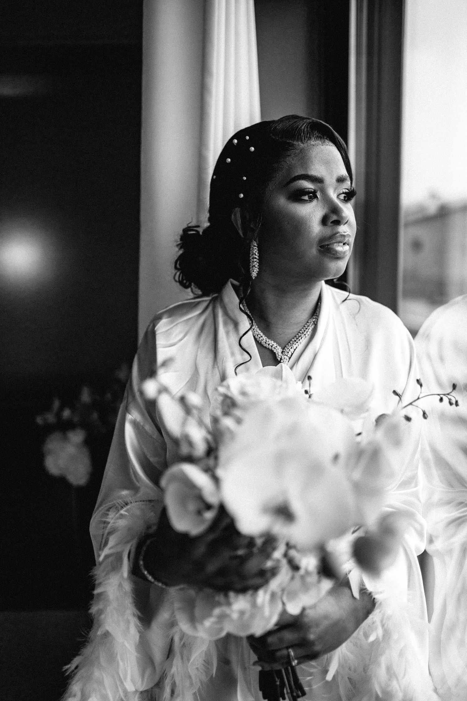 Elegant bridal preparation scene with white floral arrangements and soft window lighting.