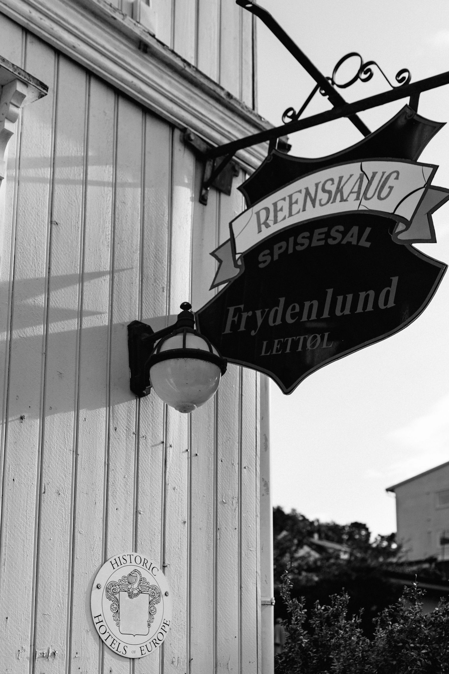 Vintage black and white shop signs mounted on a wooden wall in Scandinavian style.