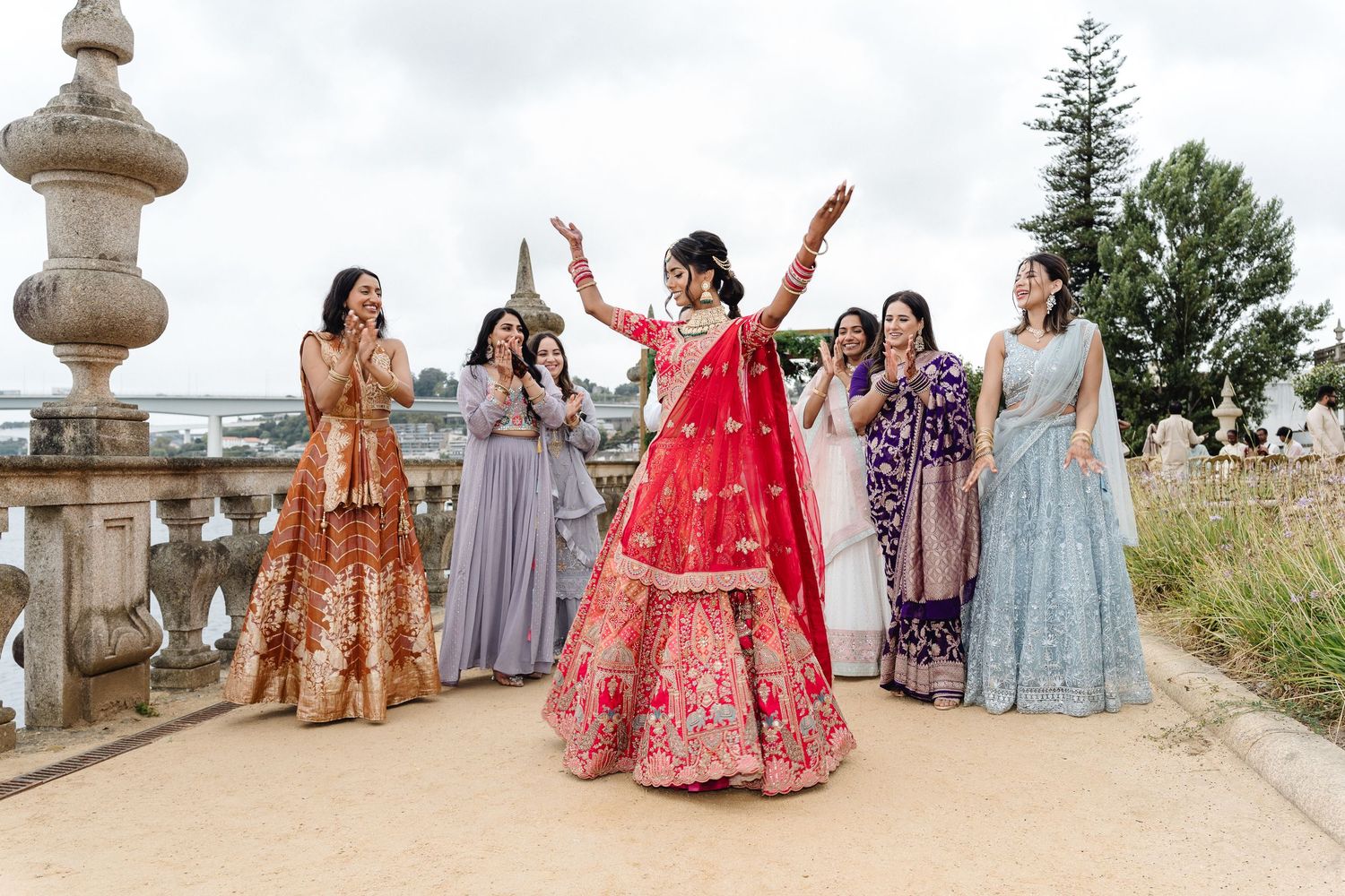 Wedding guests in colorful traditional Indian attire posing for group photo at elegant venue.