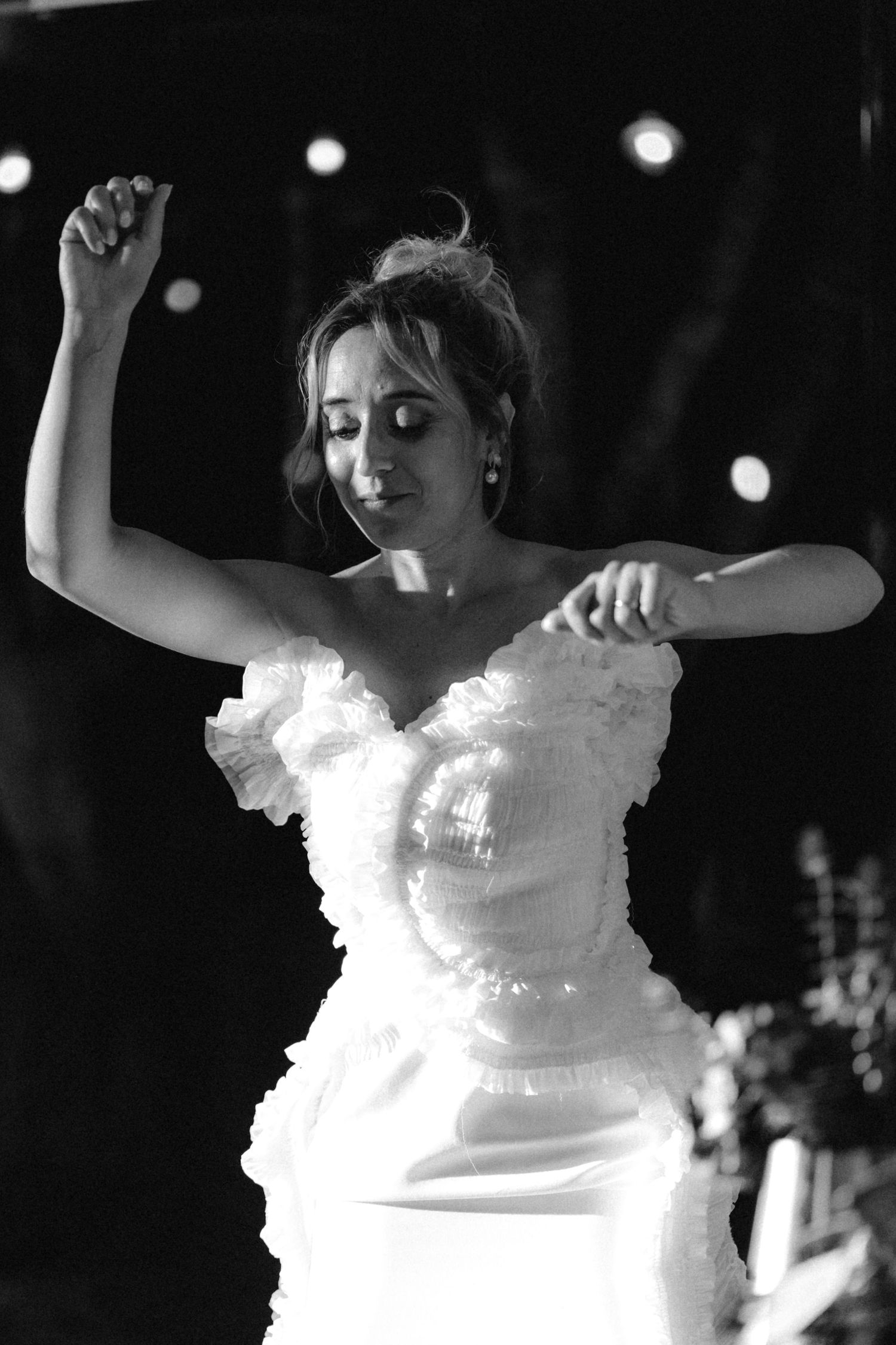 A black and white photo of someone dancing at a celebration.