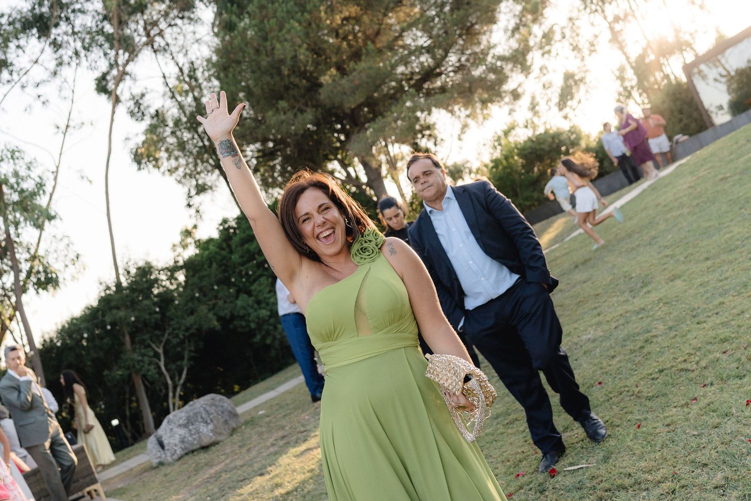 Guests dancing and celebrating on grassy lawn at outdoor wedding reception.