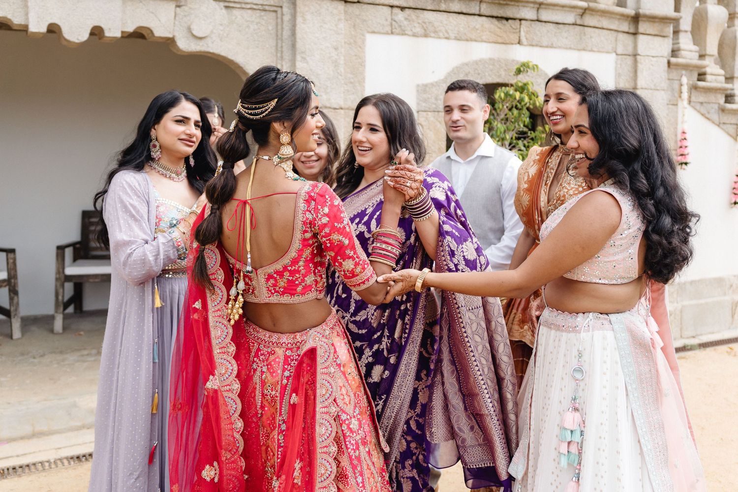 Wedding celebration with guests in traditional Indian attire dancing and celebrating.