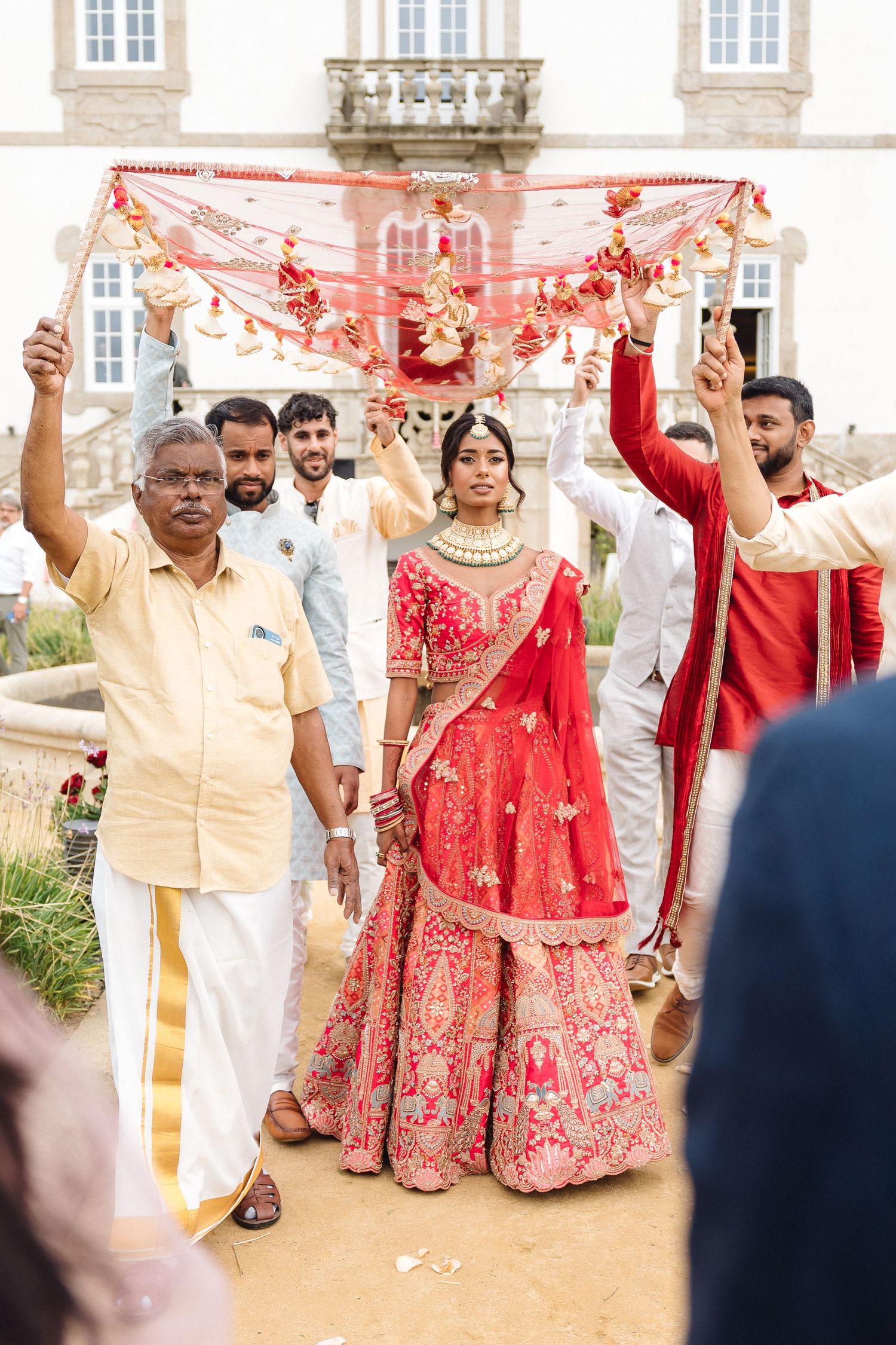 Wedding celebration with red dupatta ceremony on elegant outdoor terrace.