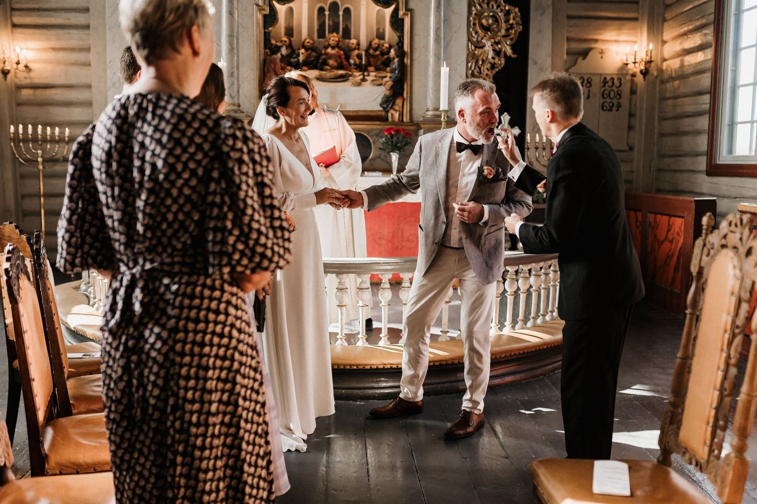 Couples swing dancing in a rustic wooden interior with vintage decor and warm ambient lighting.